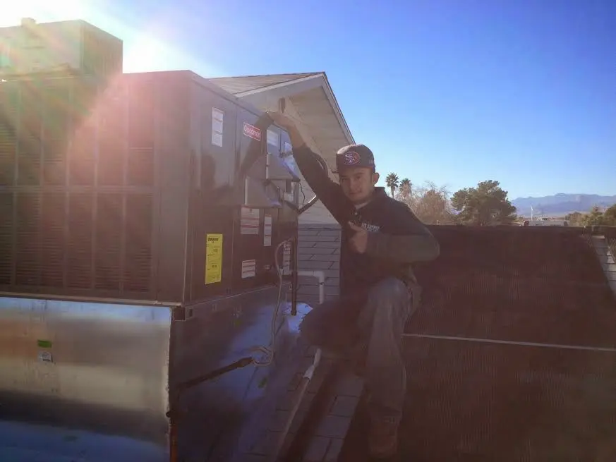HVAC technician performing Air Duct Cleaning on a rooftop unit in Chattanooga