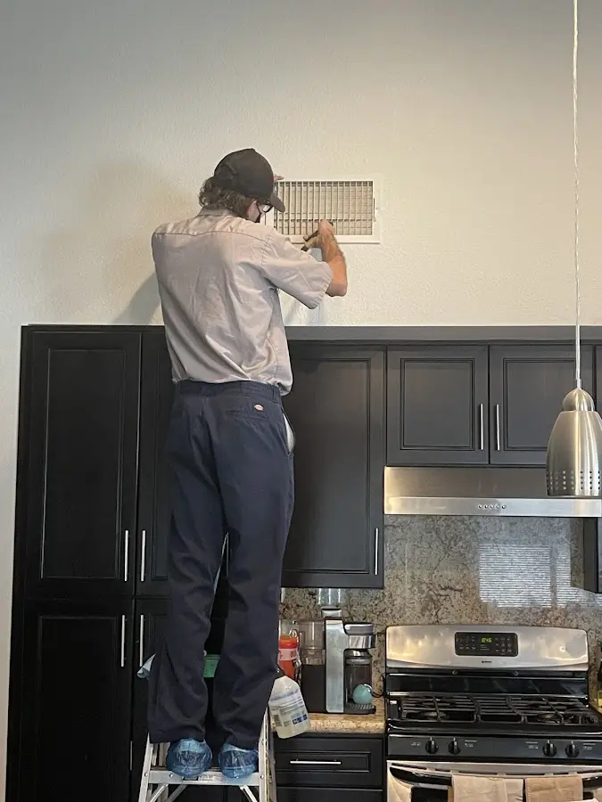Technician inspecting an air vent during HVAC service in Chattanooga